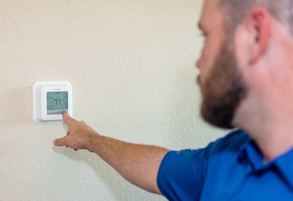 Steven Sherrell helps a customer program a thermostat